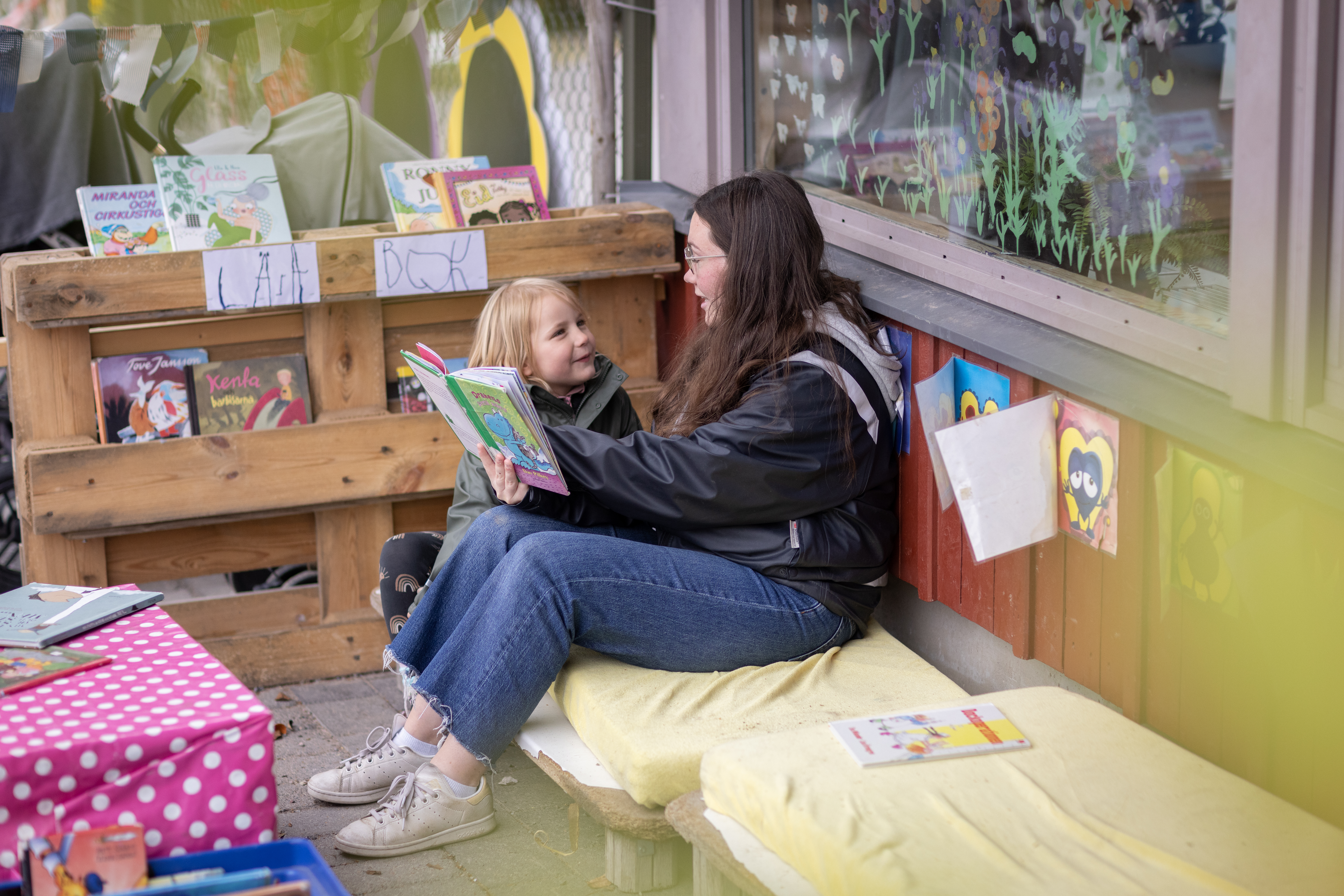 Pedagog läser utomhus för ett barn