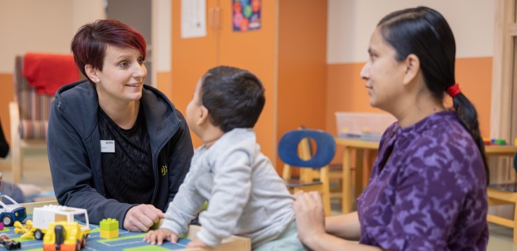 Josephine (till vänster) pratar med en mamma och hennes barn på öppna förskolan.